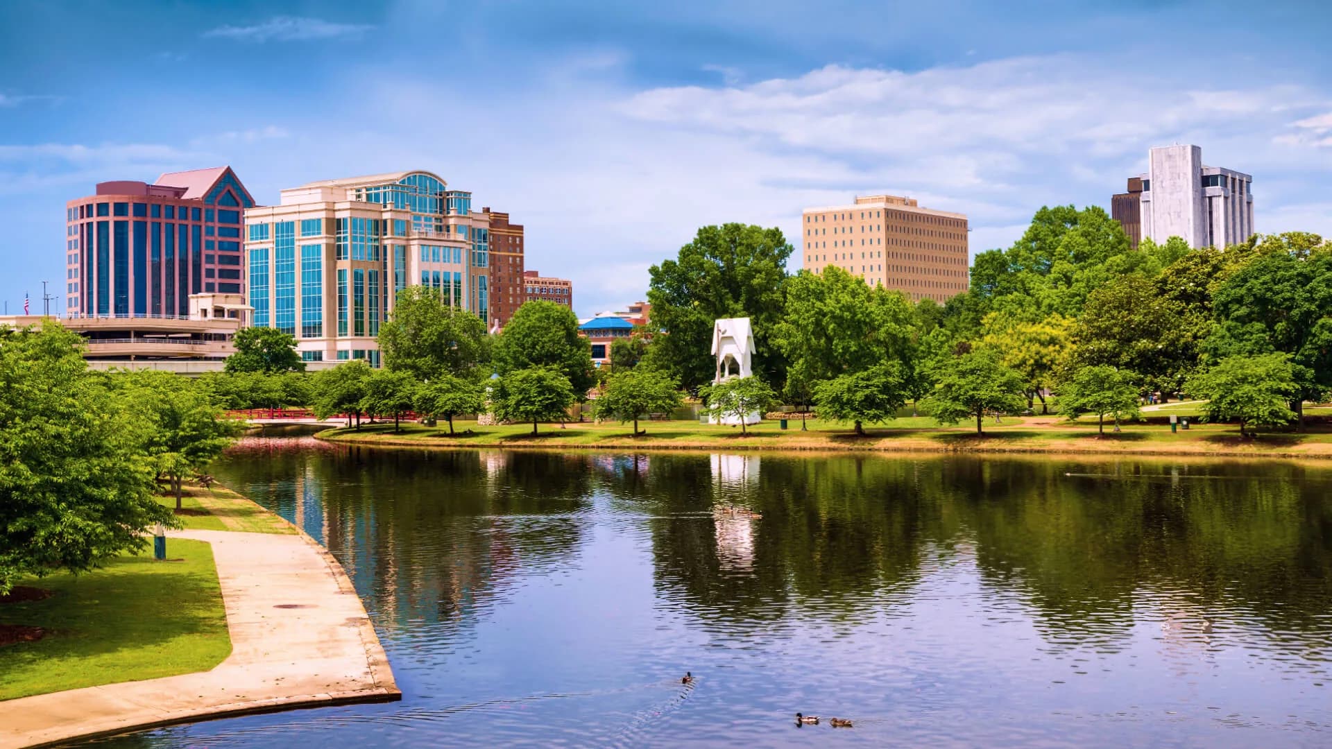Downtown Huntsville skyline beside a landscaped park pond